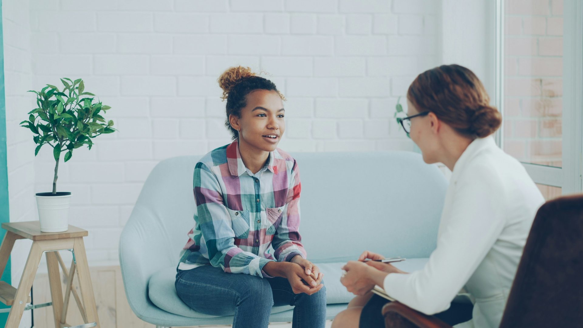 Deux femmes discutent dans un bureau moderne.